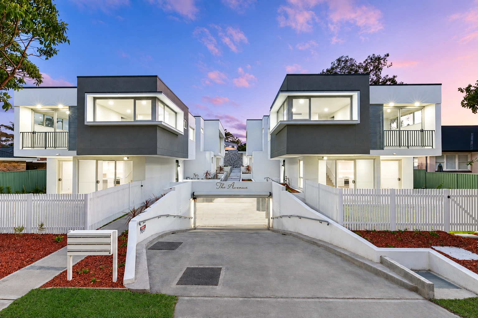 Contemporary homes at President Avenue, Miranda, illuminated against the evening sky